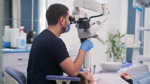 Dentist Using Microscope to Examine Patient's Teeth