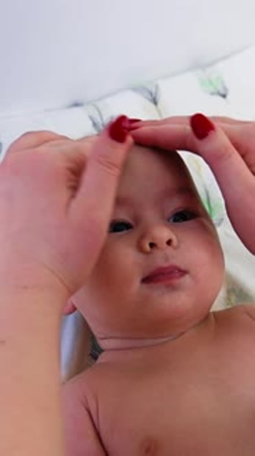 Doctor's hands checking baby's head, touching him gently and carefully.