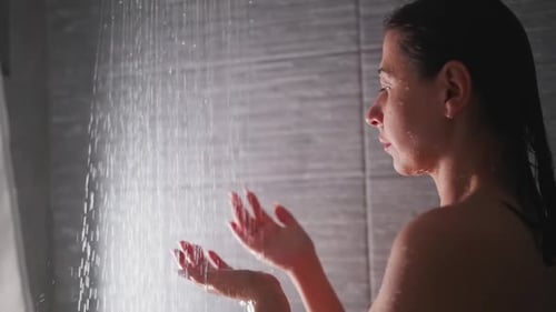 Woman Enjoying Shower, Holding Hands Under Water