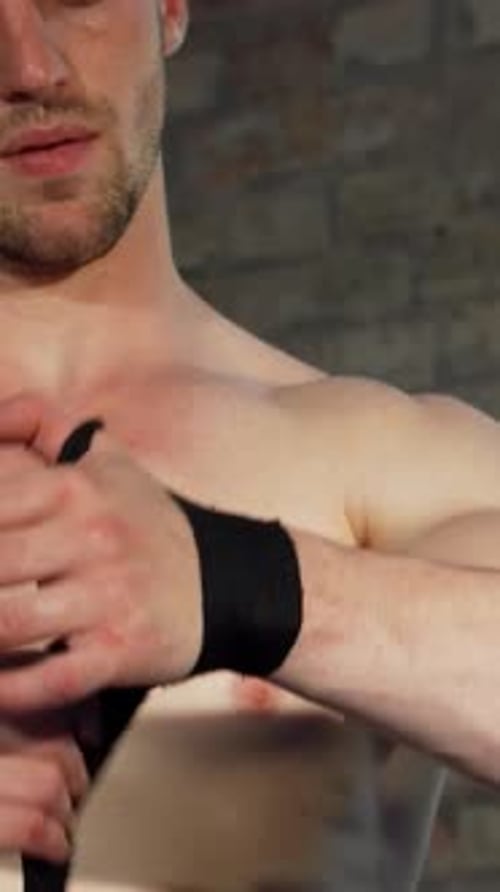 Man Wraps Wrist with Elastic Athletic Bandage