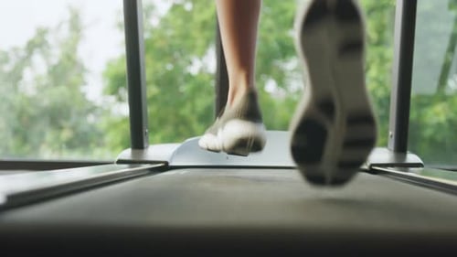 Asian female runner cardio running on techno machine treadmill start morning routine lifestyle.