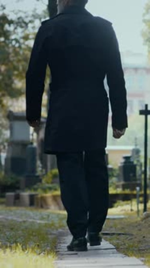Hombre pasando por el cementerio el día de otoño