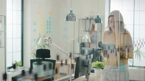Beautiful Young Woman Walks through the Office while Using Digital Touch Screen Tablet Computer. Mo