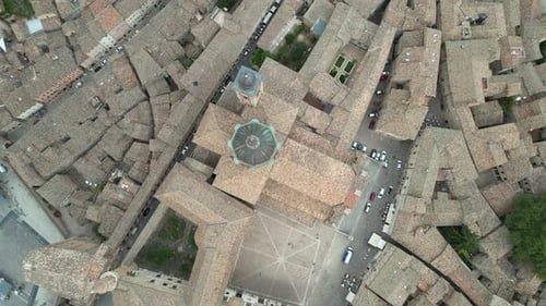 A bird's-eye view of Urbino's historic center highlights its iconic cathedral dome, adjacent piazza,