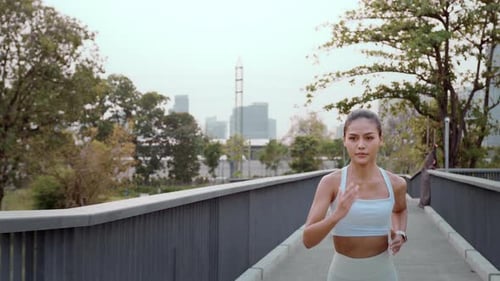 Young fitness woman in sportswear jogging in city park