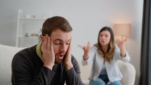 Un agresseur de Angry Fury Woman crie un homme fermant ses oreilles
