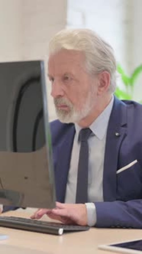 Senior Man Working on Computer in Modern Office
