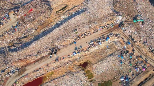 Drones are flying over large garbage pile of plastic waste