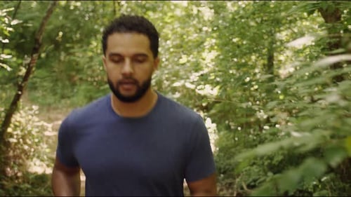 Young male jogging through forest