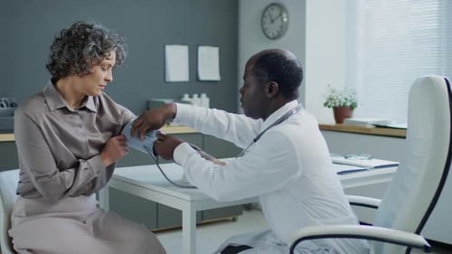 Doctor Measures Patient's Blood Pressure in Office