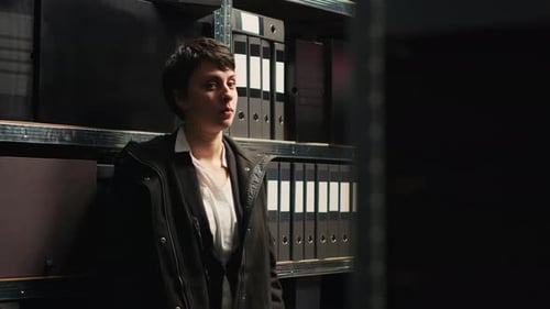 Young Woman Standing in Dimly Lit Records Room