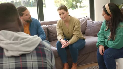 Diverse group of friends talking and supporting each other in group therapy session