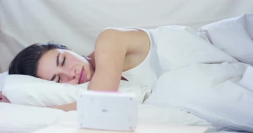 Woman Asleep Turns off Alarm Clock in Bed