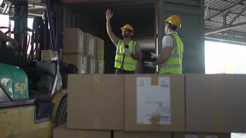 Blue collar workers are working at warehouse.