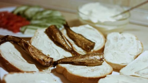 Las manos untan mayonesa sobre mantequilla de pan