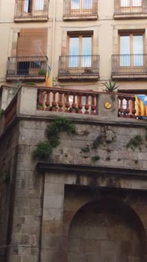 Vertical panning view inside Gothic neighborhood, Barcelona, Catalunya flag, traditional buildings a