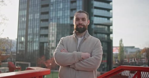 Bearded Man Poses in Urban Setting, Arms Crossed