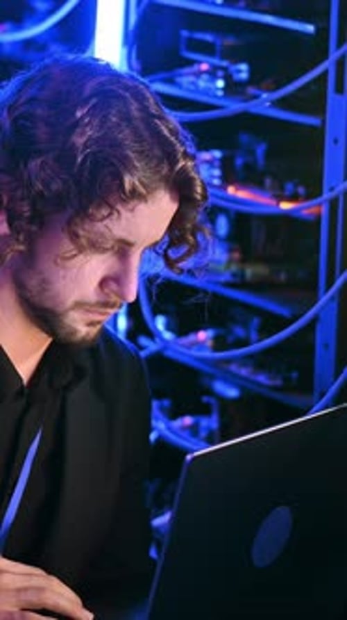 System Administrator Working on Laptop at Data Center