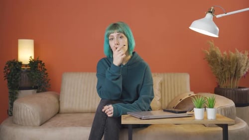 Pensive Woman Sitting on Couch Indoors
