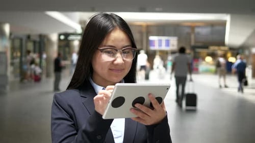 Young Woman Using Tablet in Public Location