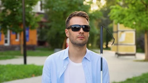 Blind Man Sitting on the Bench and Holding Walking Long Cane