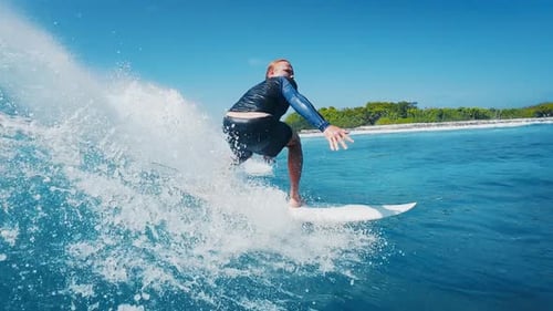 Surfer rides the wave in the ocean in the Maldives