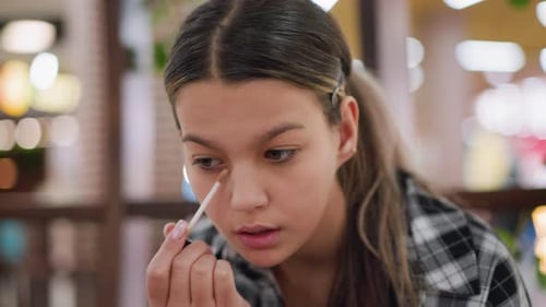 Young Woman Applying Makeup in Urban Location