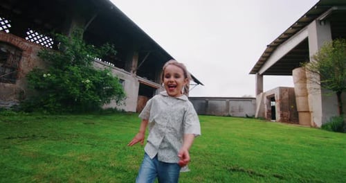 Happy Child Running on Green Lawn in Rural Setting
