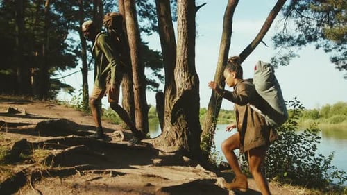 Two Afroamerican Sporty People Man and Woman Hiking in the Woods Climbing Up Hills Supporting