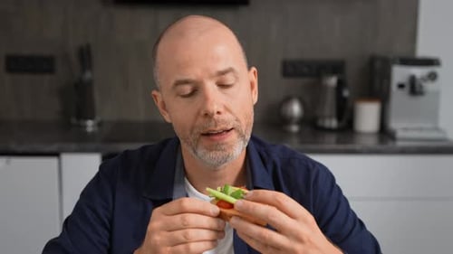 Man enjoying a healthy vegetable sandwich at home