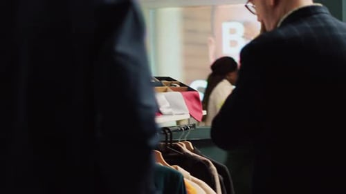 Shoppers Browsing Clothing Racks in Busy Store