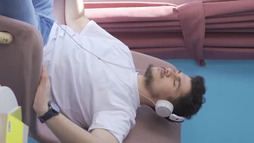 Young Adult Relaxing, Listening to Music with Headphones