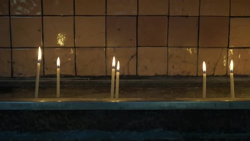 Row of Burning Candles in a Church