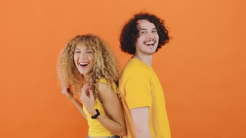 Smiling Young Adults Standing Back to Back