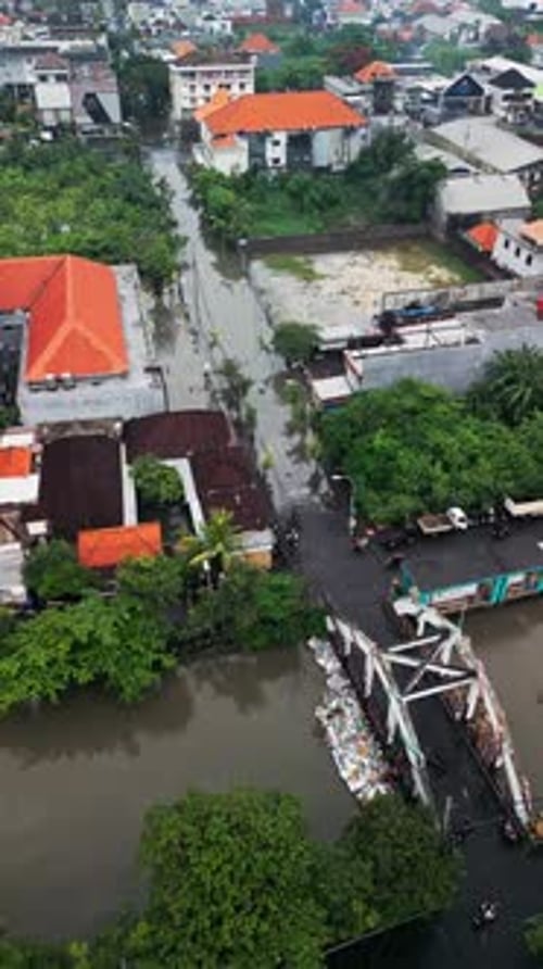 Vertical Aerial View of River Flooding in Bali with Water Covering Roads and Neighborhoods