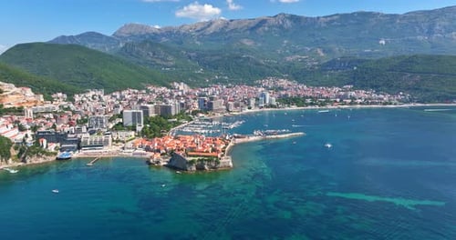 Aerial tracking shot of the city shoreline of Budva, summer day in Montenegro