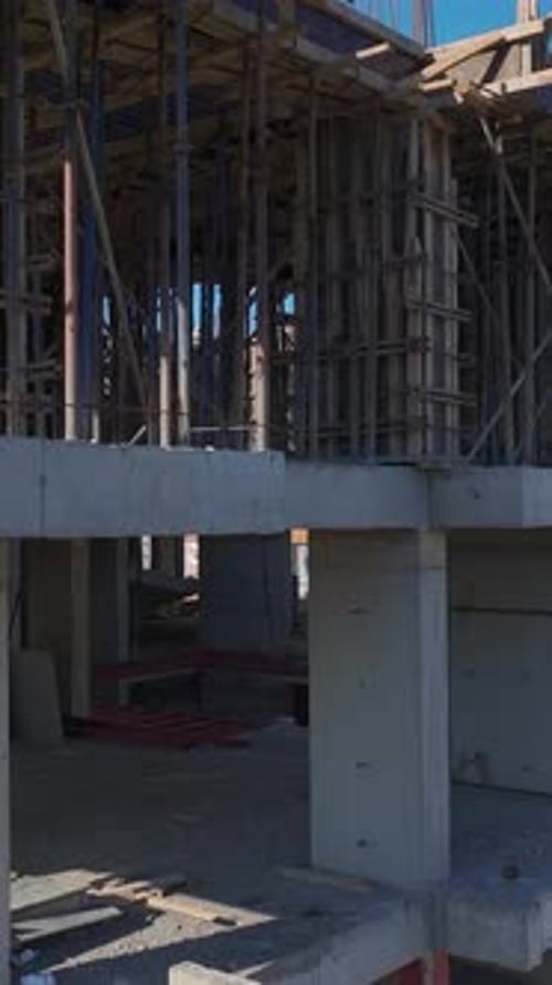 Vertical Video of Engineers Checking Blueprints on a Construction Site With Workers in Action