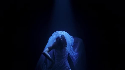 Woman wearing wedding dress posing in dark studio