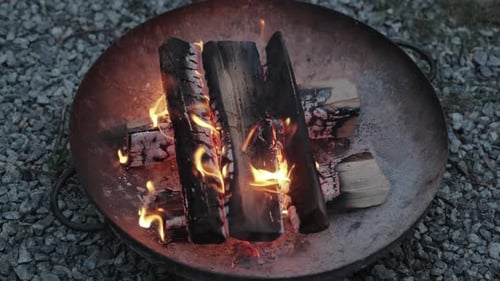 Burning Firewood in Rustic Metal Fire Pit