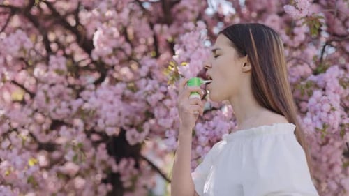 Femme utilisant un inhalateur pendant la floraison printanière en extérieur