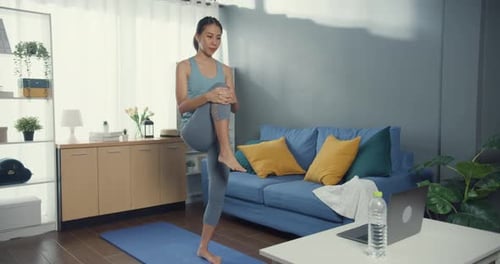 Woman Exercises On Yoga Mat in Living Room