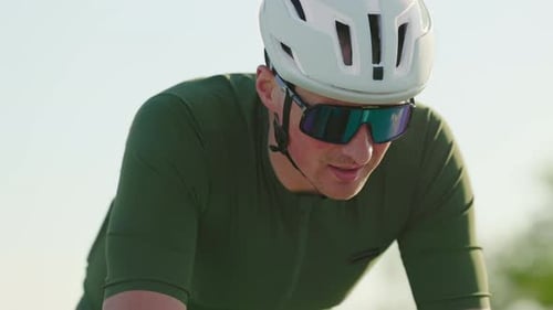 Cyclist Wearing Helmet and Sunglasses Riding Bike