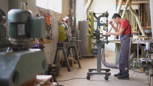 Adult Using Drill Press in Woodworking Shop