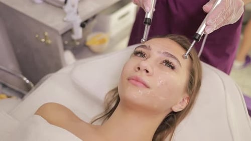 A Woman is Currently Experiencing a Rejuvenating Facial Treatment at a Luxurious Beauty Spa Designed