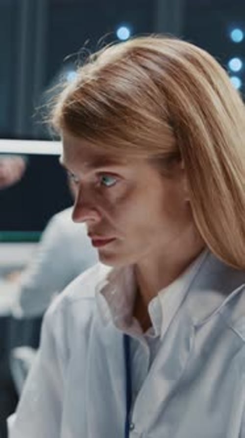 Woman in lab coat working in server room