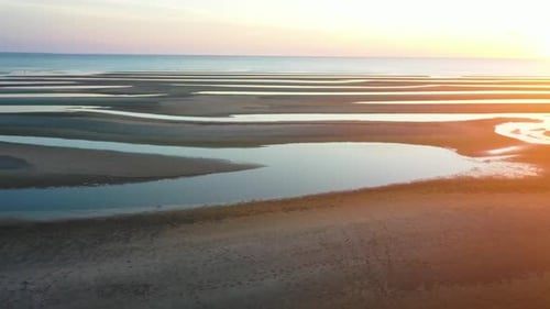 Shallow Low Tide Beach Aerial Drone Footage of Sand Bars and Water Puddles at Golden Hour, Sliding R