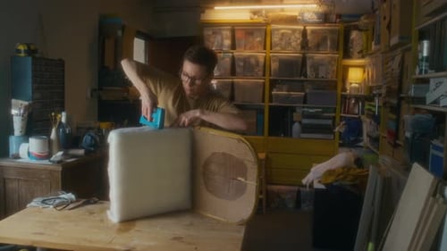 Young Adult Upholstering Furniture in Workshop