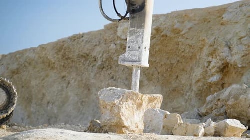 Excavator with Hydraulic Hammer Breaking Stone