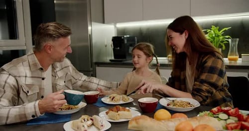 Family of Three Enjoying Meal Together in Kitchen