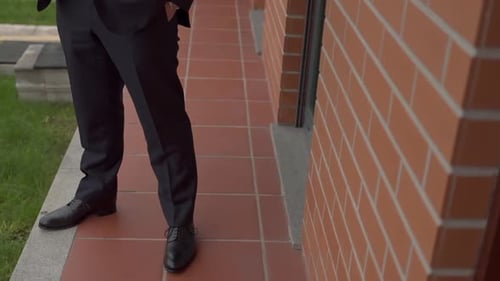 Man in Formal Suit Standing on a Terrace